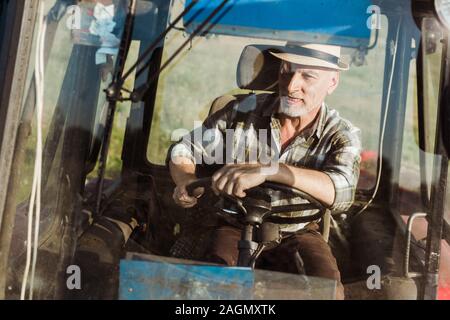 Portrait of smiling farmer autonomes tout en conduisant le tracteur Banque D'Images