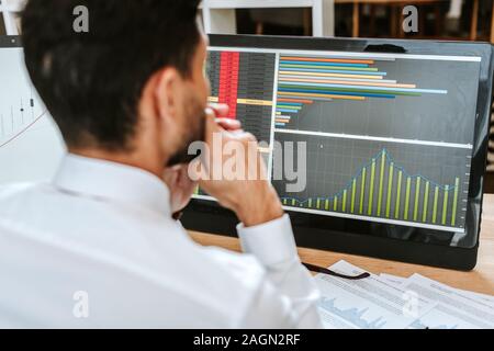 Focus sélectif de bi-raciale à l'opérateur à l'ordinateur avec des graphiques Banque D'Images