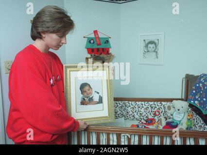 Deborah Eappen se trouve à côté de son fils mort Matthieu d'enfant tenant un portrait de lui dans sa chambre à coucher à leur domicile, à Newton, Ma Nov 1997. photo exclusive par Bill Belknap Banque D'Images