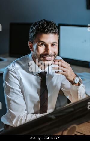 Portrait of smiling bi-raciale trader looking at camera Banque D'Images