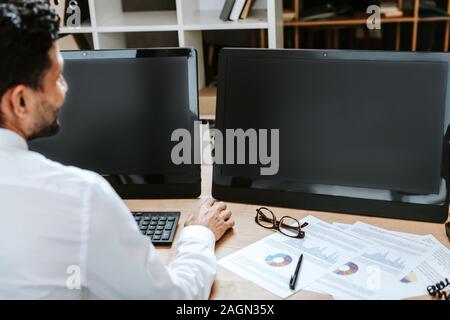 Focus sélectif de bi-raciale trader assis à table avec les ordinateurs Banque D'Images