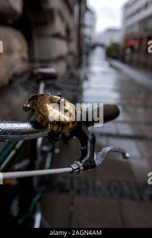Close up de la cloche en laiton d'un vélo stationné dans une rue de Munich sur un jour de pluie Banque D'Images