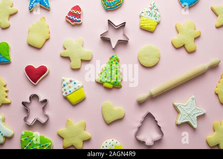 Motif de biscuits de Noël et d'un emporte-pièce avec rouleau à pâtisserie résumé sur rose. Banque D'Images