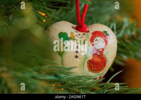 Décoration de Noël en forme de coeur vintage en papier avec une photo d'un bonhomme de neige et d'une bonde de neige. Banque D'Images