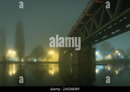 Un pont de chemin de fer d'acier de l'époque victorienne sur une rivière sur un hivers brumeux atmosphérique moody, nuit. Worcester, River 7, UK Banque D'Images