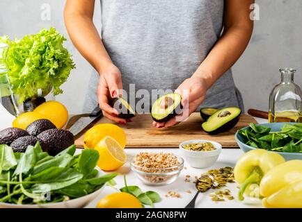 Les deux moitiés d'avocat bien mûr de femmes. La cuisson des aliments sains concept Banque D'Images