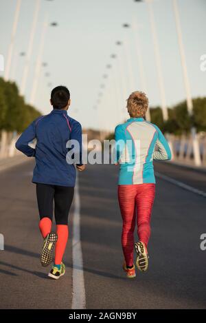 D'un coup de recul des couple jogging ensemble dans leur quartier, Alicante, Espagne Banque D'Images