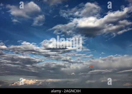 Parachutiste dans le ciel. un parachute solitaire parmi de beaux nuages. Parachutiste sur parachute coloré coucher de soleil lever du soleil Ciel. Passe-temps actif Banque D'Images