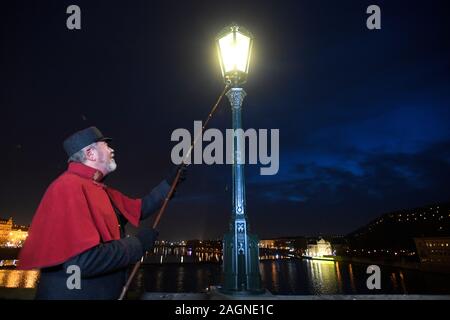 Prague, République tchèque. 18Th Oct, 2019. Le Lamplighter Jan Zakovec s'allume gaz traditionnel éclairages sur le Pont Charles, dans le centre de Prague, en République tchèque, le vendredi, Décembre 20, 2019. Credit : Ondrej Deml/CTK Photo/Alamy Live News Banque D'Images