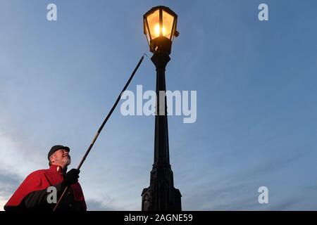 Prague, République tchèque. 18Th Oct, 2019. Le Lamplighter Jan Zakovec s'allume gaz traditionnel éclairages sur le Pont Charles, dans le centre de Prague, en République tchèque, le vendredi, Décembre 20, 2019. Credit : Ondrej Deml/CTK Photo/Alamy Live News Banque D'Images