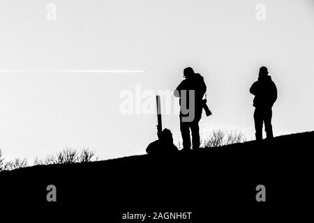 Une image en noir et blanc d'un photographe qui se profile sur une colline. Banque D'Images
