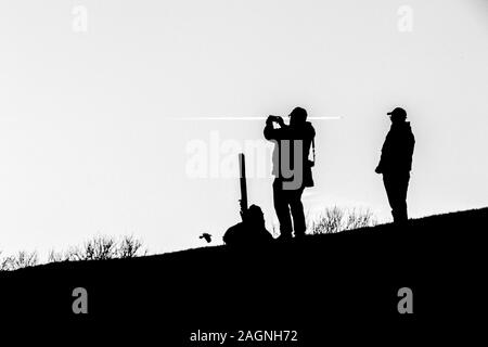 Une image en noir et blanc d'un photographe qui se profile sur une colline. Banque D'Images