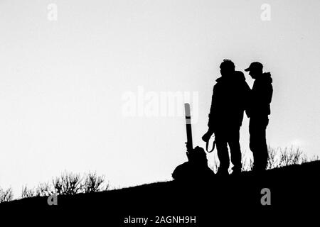 Une image en noir et blanc d'un photographe qui se profile sur une colline. Banque D'Images