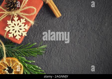 Noël ou Nouvel An arrière-plan noir avec décorations à partir de matériaux naturels - arbre de Noël de brindilles, de cannelle, d'orange séchée et flocon en bois Banque D'Images