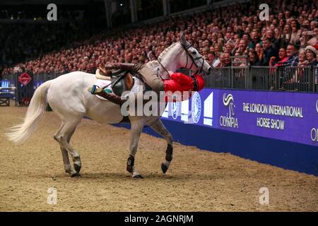 Sir Anthony McCoy tombe bien que concurrentes dans les jockeys Markel, saut à l'aide du Fonds au cours de la classe des jockeys blessés jour cinq de la London International Horse Show à l'Olympia de Londres. Banque D'Images