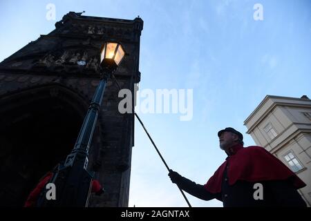 Prague, République tchèque. 18Th Oct, 2019. Le Lamplighter Jan Zakovec s'allume gaz traditionnel éclairages sur le Pont Charles, dans le centre de Prague, en République tchèque, le vendredi, Décembre 20, 2019. Credit : Ondrej Deml/CTK Photo/Alamy Live News Banque D'Images