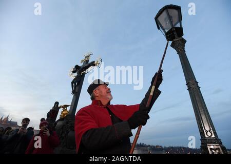 Prague, République tchèque. 18Th Oct, 2019. Le Lamplighter Jan Zakovec s'allume gaz traditionnel éclairages sur le Pont Charles, dans le centre de Prague, en République tchèque, le vendredi, Décembre 20, 2019. Credit : Ondrej Deml/CTK Photo/Alamy Live News Banque D'Images