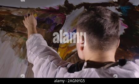 Concepteur de l'artiste dessine un aigle sur le mur. Décorateur artisan photo peintures à l'acrylique couleur d'huile. Peintre peintre vêtu de couche de peinture. À l'intérieur. Banque D'Images