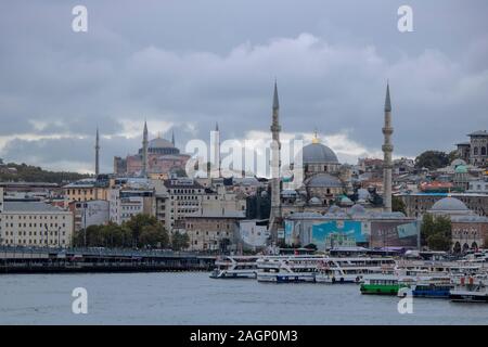 Istanbul, Turquie - Octobre-5.2019:La mosquée dans le district d'Eminonu et bateaux vente de poissons grillés. À gauche est une partie de le pont de Galata. Banque D'Images