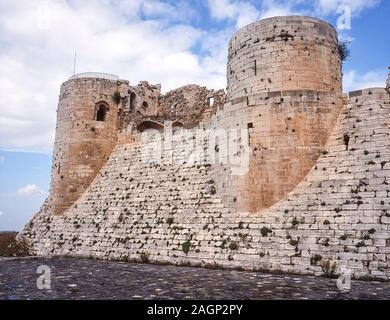 Syrie. Les murs défensifs extérieurs aux ruines de la vaste forteresse de Crusader du Krak des Chevaliers, la forteresse des Chevaliers, la porte D'entrée D'Qa'lat al Hosn entre la Syrie et la Méditerranée. Construite au XIIe siècle, la forteresse fut le bastion des Templiers européens pendant les guerres Saints Banque D'Images