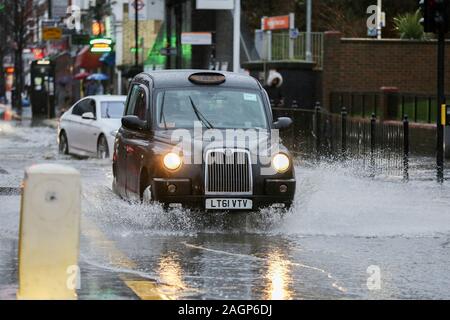 Green Lanes, Harringay, Nord de Londres. UK. 20 Dec 2019 - Un taxi londonien noir passe par une inondation sur Green Lanes, dans le nord de Londres Harringay, causée par les fortes pluies la nuit et d'un éclatement du tuyau. Credit : Dinendra Haria/Alamy Live News Banque D'Images