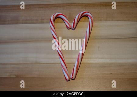 Orlando, FL/USA-12/20/19 : canne de sucrerie aromatisée à la menthe poivrée traite dans une forme de coeur c sur une planche de bois. Banque D'Images