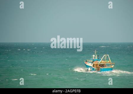 Un petit bateau de pêche faisant route vers la mer pour commencer la pêche. Banque D'Images