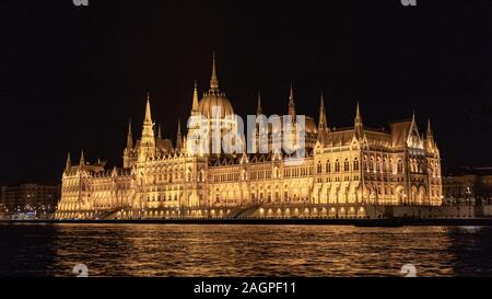 Parlement de Budapest illuminé la nuit au bord de la rivière Banque D'Images