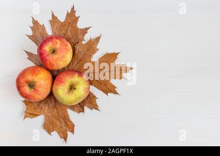 Composition d'automne. Des pommes mûres, des feuilles sèches sur un fond de bois blanc. L'automne fête de l'arrière-plan. Concept de récolte d'automne. Mise à plat, vue du dessus Banque D'Images
