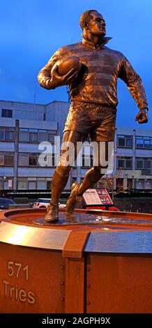 Billy Boston statue , le MBE Wiend, Wigan, Greater Manchester, Angleterre, RU, WN1 1YB au crépuscule ( William John Boston ) Banque D'Images