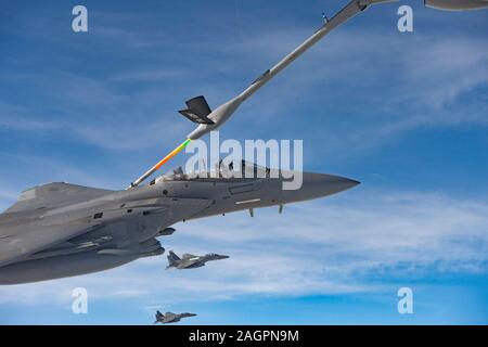 U.S. Air Force F-15E Strike Eagles affecté à la 494e Escadron expéditionnaire, faire le plein d'un KC-135 Stratotanker affecté à la 28e Escadron expéditionnaire de ravitaillement en vol en route pour participer à une formation voler plus de respect la Qatar National Day, 18 Décembre, 2019. Le KC-135 Stratotanker offre U.S. Air Forces Central Command une portée mondiale et une capacité de ravitaillement en vol pour soutenir notre joint et les avions de la coalition, fournissant la puissance aérienne de gagner la guerre dans toute la zone de responsabilité. (U.S. Air Force Photo par SSgt Bethany La Ville) Banque D'Images