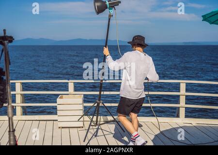 Gaffer ou le chef électricien dans une motion-photo ou de télévision de l'unité de production mis en place l'éclairage et la lumière se tiennent sur un tournage commercial Banque D'Images