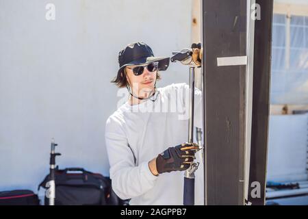 Gaffer ou le chef électricien dans une motion-photo ou de télévision de l'unité de production mis en place l'éclairage et la lumière se tiennent sur un tournage commercial Banque D'Images