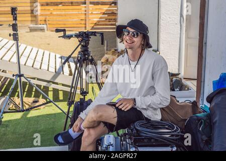 Gaffer ou le chef électricien dans une motion-photo ou de télévision de l'unité de production mis en place l'éclairage et la lumière se tiennent sur un tournage commercial Banque D'Images