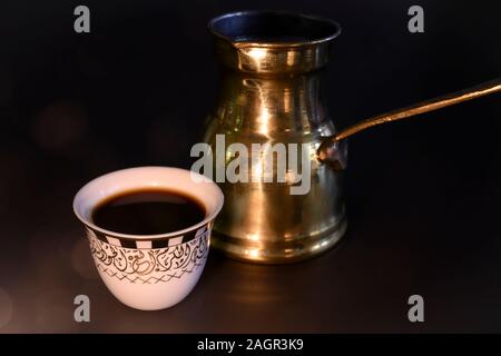 Une tasse de café turc et de cizve aux chandelles Banque D'Images