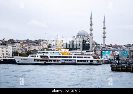 Istanbul, Turquie - Octobre-5.2019:La mosquée dans le district d'Eminonu et bateaux vente de poissons grillés. À gauche est une partie de le pont de Galata. Banque D'Images