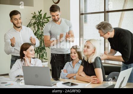 Employés saluent l'un d'entre eux une jeune femme a obtenu la reconnaissance et le respect Banque D'Images