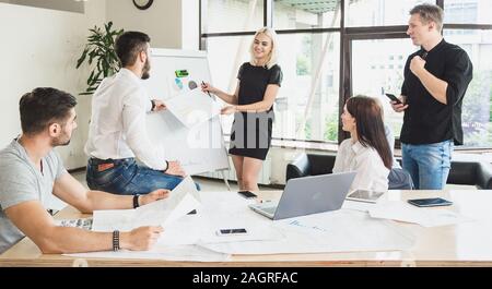 Le processus de travail. Habillé en passant les employés dans le processus de discussion du projet sont lumineux et spacieux bureau Banque D'Images