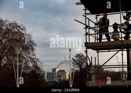 La préparation d'une plate-forme d'échafaudage pour un équipage de caméras de télévision à Buckingham Palace avec le London Eye en arrière-plan Banque D'Images