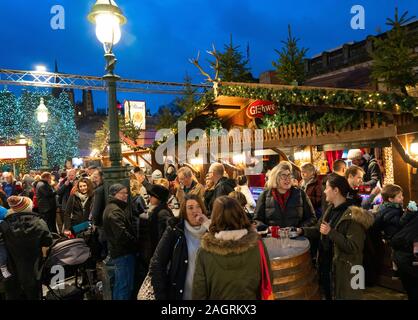 Voir des personnes manger et boire à l'étal dans Édimbourg occupé Marché de Noël dans l'ouest des jardins de Princes Street à Édimbourg, Écosse, Royaume-Uni Banque D'Images