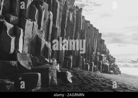 Photo en noir et blanc des grandes formations rocheuses sur la plage de sable Banque D'Images