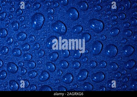 Un close up abstract macro photo de gouttelettes d'eau sur une poêle non stick gris avec un matériau gel flash bleu Banque D'Images