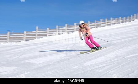 Femme à Sinaia ski resort en Roumanie sur une journée ensoleillée avec une parfaite de la neige, sur une pente moyenne difficulté (piste rouge), sur tous les skis de montagne panoramique - sh Banque D'Images