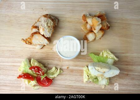 Ingrédients pour la salade César sur un bureau en bois mise à plat Banque D'Images