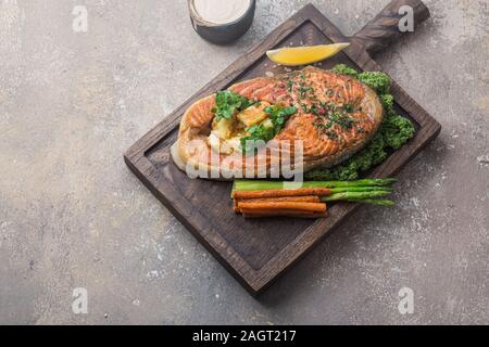Pavé de saumon aux légumes sur planche de bois, copy space Banque D'Images