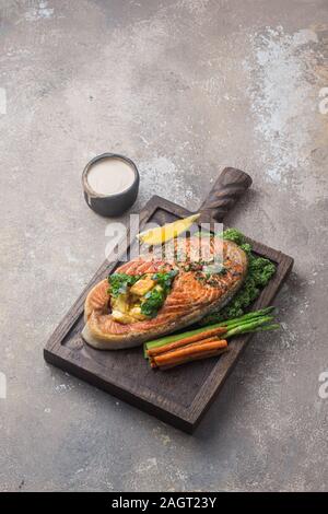 Pavé de saumon aux légumes sur planche de bois, copy space Banque D'Images