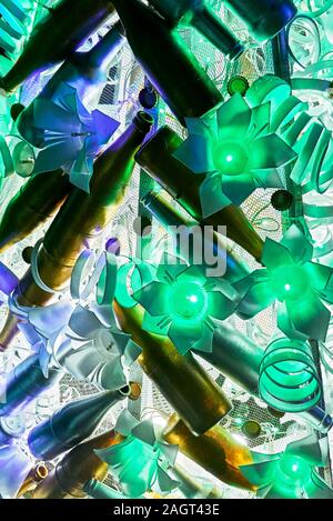 Close-up of a rare Noël Décoration des plastiques recyclés et bouteilles combinée avec des feux en forme de fleur à froid, vu dans les Philippines Banque D'Images