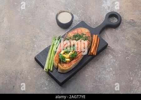 Pavé de saumon poêlé avec de la polenta sur planche de bois, copy space Banque D'Images