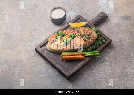 Pavé de saumon poêlé avec de la polenta sur planche de bois, copy space Banque D'Images