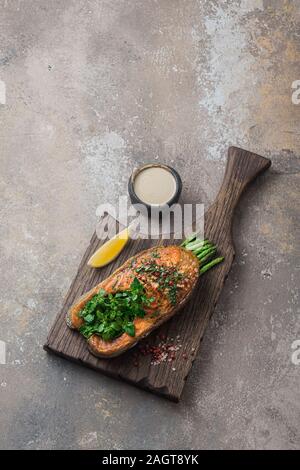 Pavé de saumon poêlé aux asperges sur planche de bois, copy space Banque D'Images